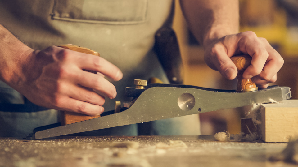 Carpenter planing a piece of timber